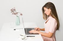 pretty brunette woman sitting at desk on laptop