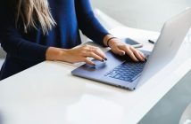 close-up of woman's hands typing on laptop