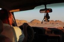 man driving car in desert